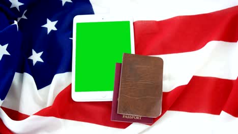 tableta digital, pasaporte y visado con bandera estadounidense