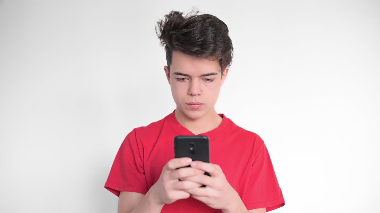 Boy is on his smartphone and getting shocked. White background