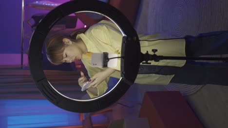 woman using ring light to create social media content