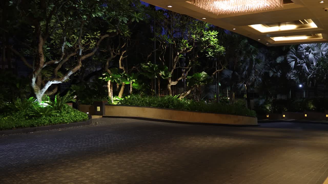 밤 에 아름답게 조명 된 공원 을 가로질러 운전 하는 차