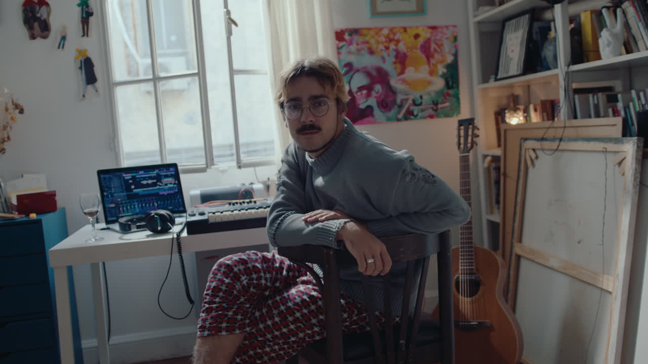 Young Musician Posing for Camera at Home Recording Studio