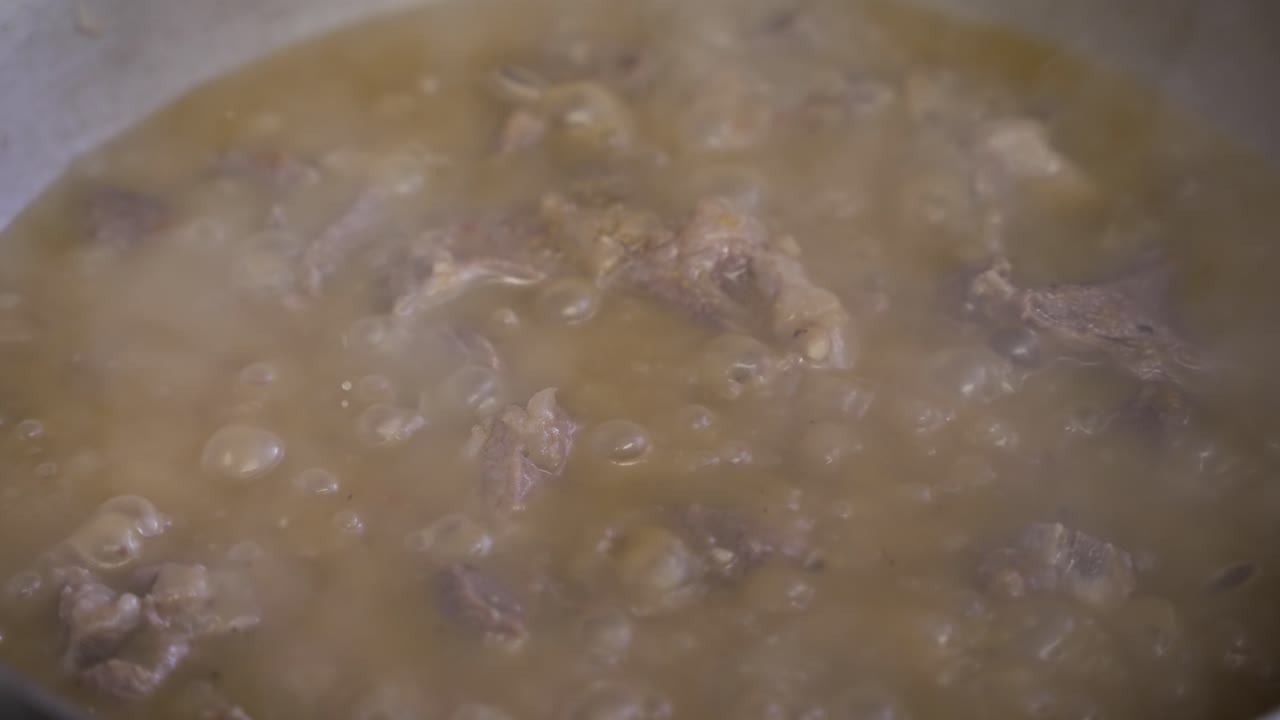 Ripresa al rallentatore di curry di carne bollente con vapore che sale, preparato in modo invitante, che evoca l'essenza della cucina gourmet e del piacere culinario