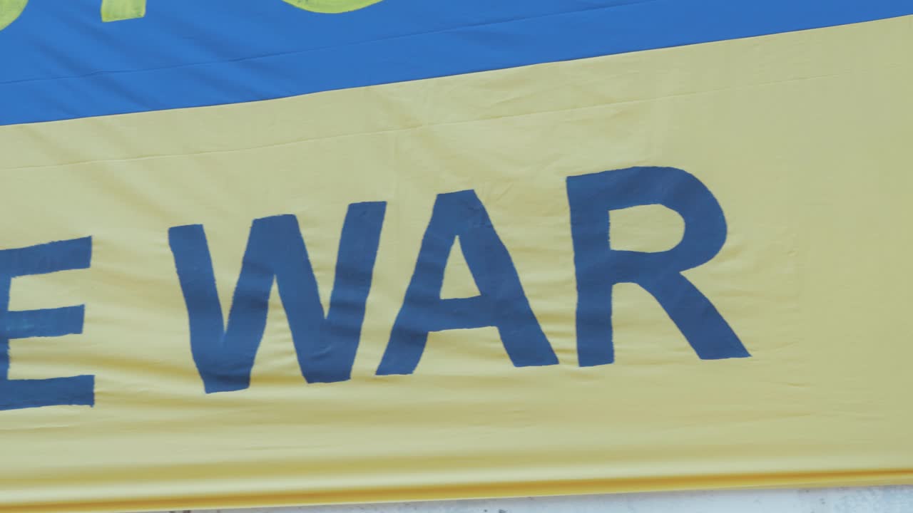 러시아 침공에 항의하여 '전쟁을 멈추라'는 문구가 있는 우크라이나 국기