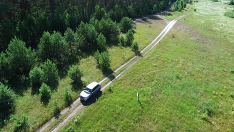 copter view driving car through fields. copter filming automobile at nature