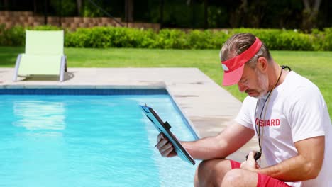 lifeguard holding clipboard and looking at stop watch