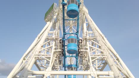 Low-angle-view-looking-up-at-moving-blue-cabins-of-Angkor-Eye-Ferris-wheel-ride,-Siem-Reap,-Angkor-Wat,-Cambodia,-static