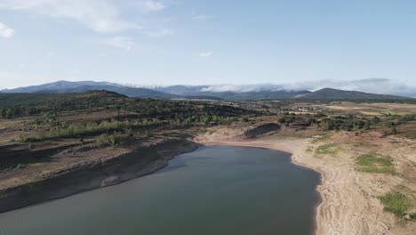 Vista-Aérea-Estática-De-Un-Embalse-Con-Un-Nivel-Bajo-De-Agua-Al-Atardecer