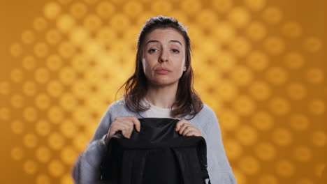 portrait of woman rummaging through backpack, taking book out