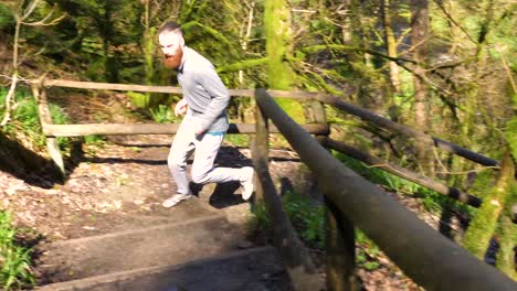 slow motion of man running up a forest carved slope