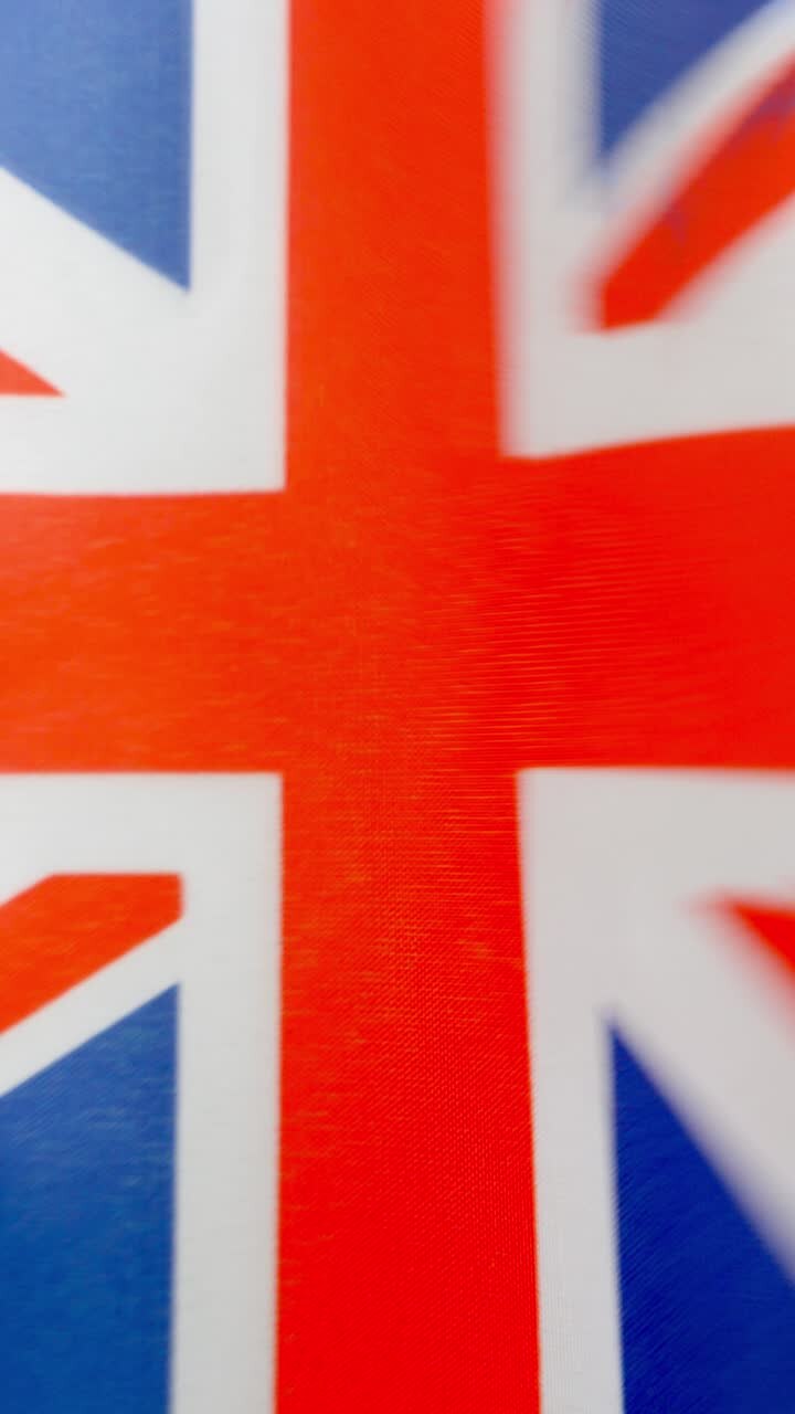 Vertical video of british national flag waving by the wind