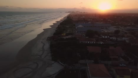 stunning establishing aerial shot of waves and beach with pink sunrise, brazil