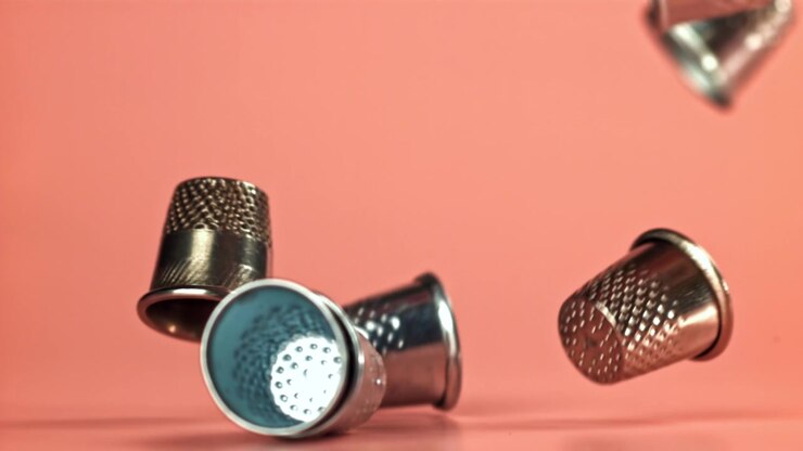 Metal Thimbles Falling in Slow Motion on Pink Background