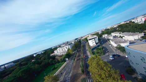 Fpv-taucherschuss,-Der-Ein-Leuchtend-Orangefarbenes-Auto-Durch-Die-Straßen-Von-Montpellier-Jagt