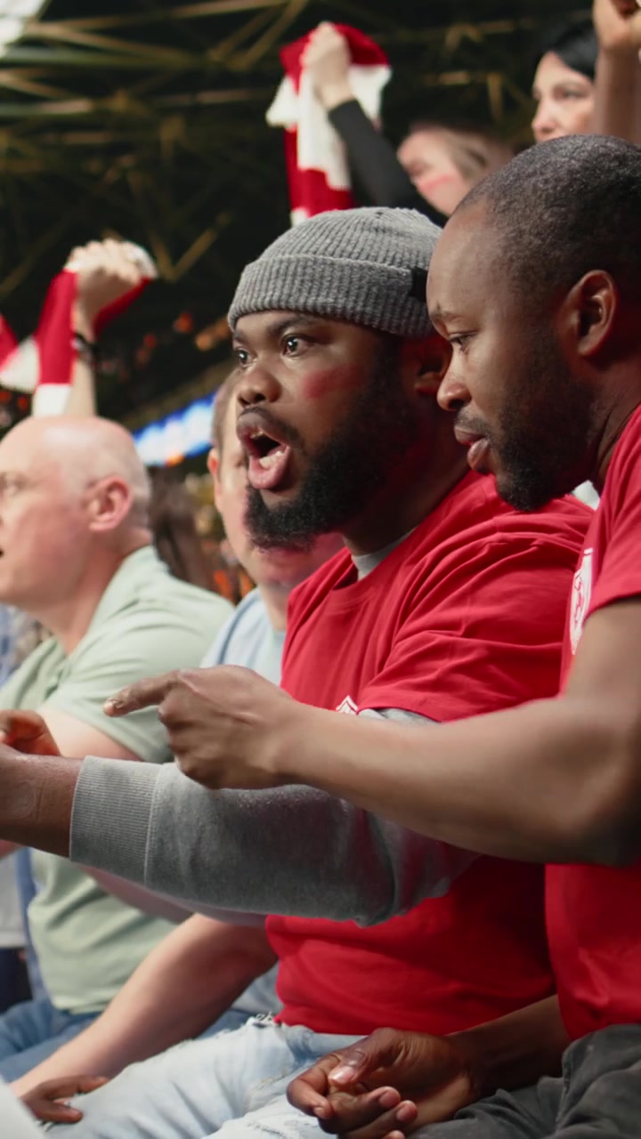 Vertical Video Passionate black fans following live betting odds on smartphone