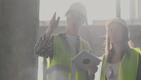 engineers or architects have a discussion at construction site looking through the plan of construction. contre jour. engineers or architects have a discussion