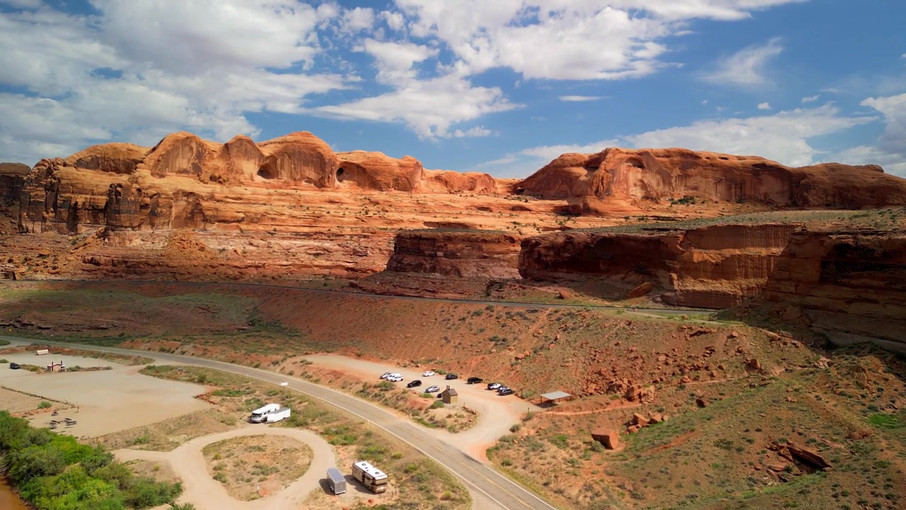 Filmato drone 4K che sorvola Moab, Utah, con l'iconico Arco Corona e il tortuoso fiume Colorado, catturando drammatici canyon di roccia rossa, paesaggi desertici e la bellezza panoramica del Sud-ovest