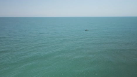 único-Pequeño-Barco-De-Pesca-Entre-Vastas-Aguas-De-Agua-Vacía