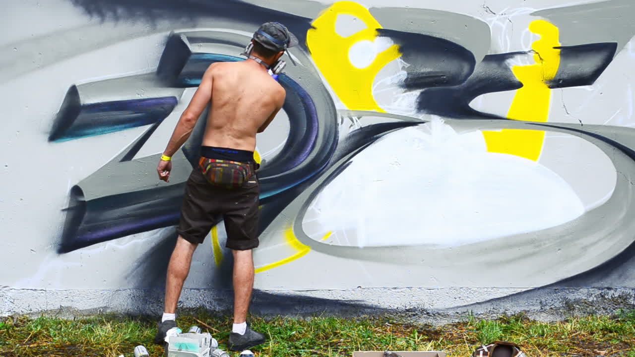 L'artista disegna graffiti su una recinzione. Graffiti su una recinzione.