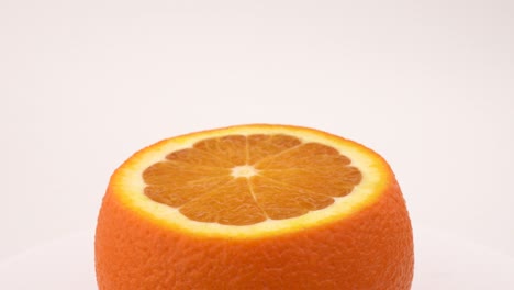 frutas de naranja cortadas rotación de primer plano en la mesa giratoria. aislado en fondo blanco. loopable. macro de primer plano.