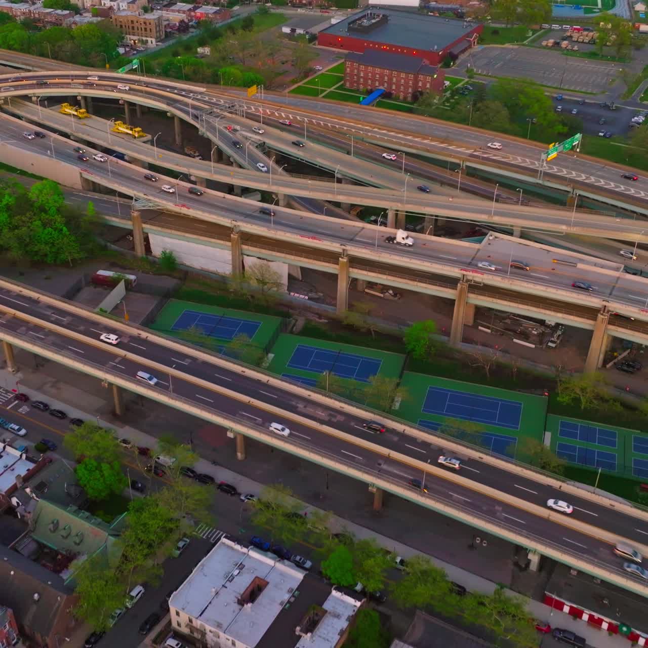 Low houses of New York and numerous parking lots. Complicated traffic system with cars moving on. Aerial perspective
