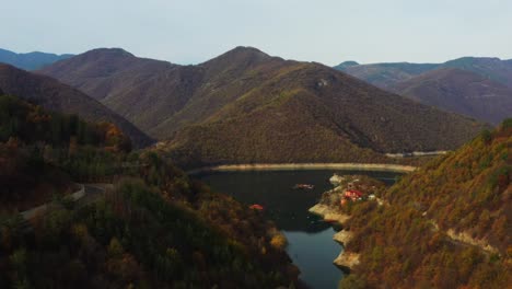 Volando-Sobre-La-Presa-De-Vucha-En-Bulgaria-Durante-Un-Colorido-Otoño-Con-Agua-Azul-A-La-Vista