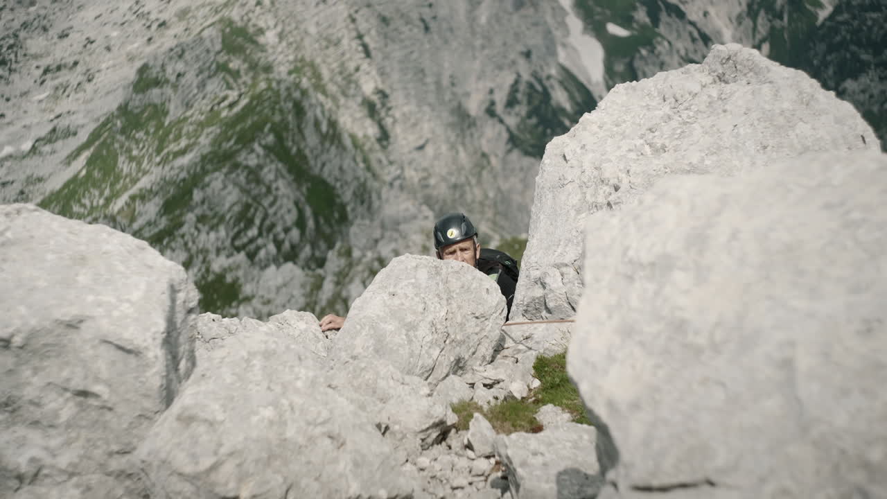 кадр, на котором турист забирается за скалу, чтобы добраться до хорошего места для подтягивания.