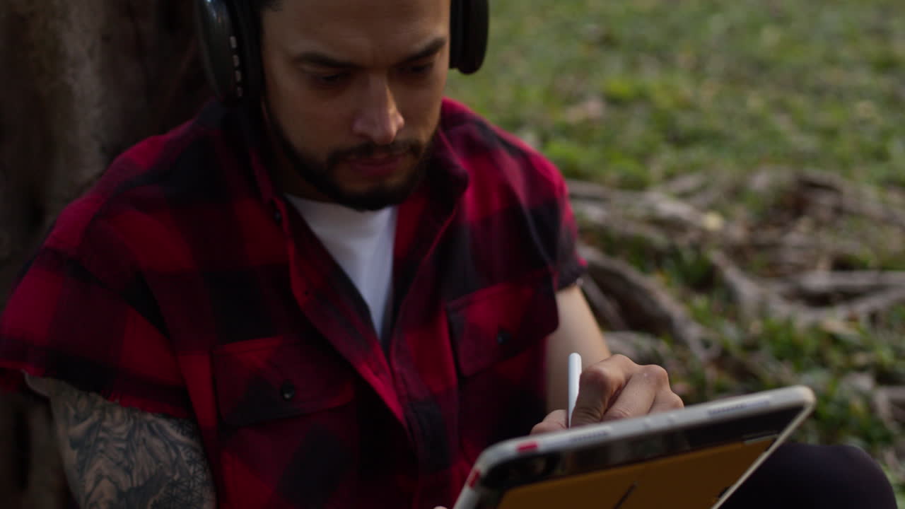 Uomo che usa un tablet in un parco