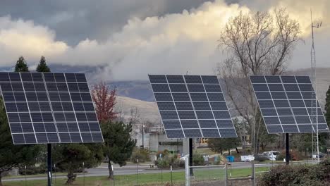 una fila de paneles solares con nubes masivas en el fondo