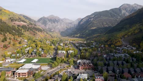 a rising drone shot in telluride valley, in the rocky mountains of colorado, on a sunny day of the fall season