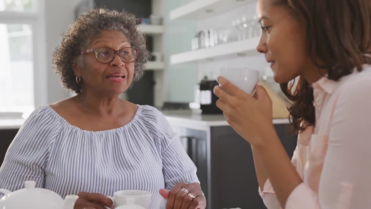 Animação de texto 'boas vibrações' sobre duas mulheres sorrindo e tomando chá em casa