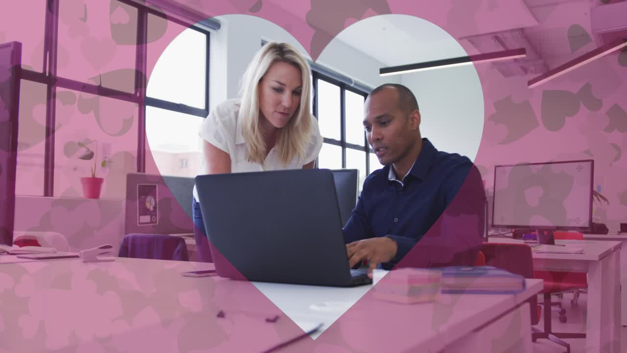 Mann und Frau prüfen einen Laptop, während eine Herzgrafik eingeblendet wird und pulsiert, im Rahmen einer geschäftlichen Zusammenarbeit.