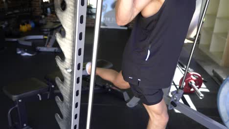 hombre del tatuaje músculos en el gimnasio en casa máquina smith estocada de una sola pierna