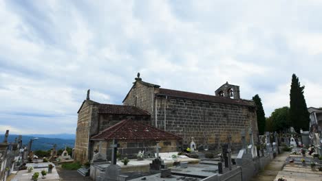 wide angle overview of santiago de gustei church with surrounding rural landscape in galicia