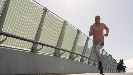 Sporty Caucasian woman exercising outdoor on a bridge