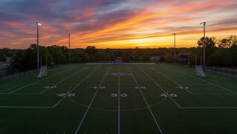 a stunning sunset over a well-maintained sports field, with vibrant colors illuminating the evening sky, perfect for evening games and events