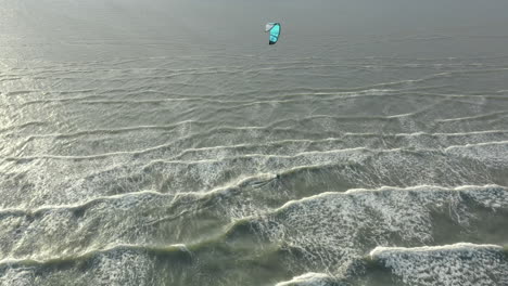 Kite surfer close to the beach, riding the wind with his kite, Drone footage