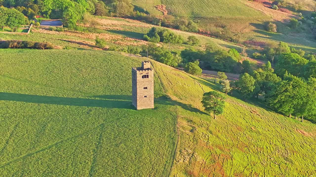 Tower in a green, hilly landscape