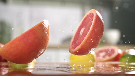 slow motion of sliced in half grapefruit falling on wet wooden board in a kitchen