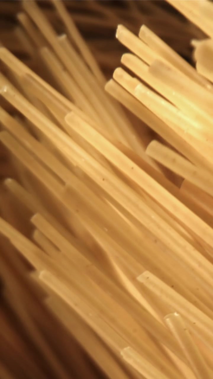 Primo piano macro di spaghetti secchi che si muovono.