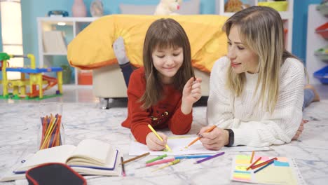madre feliz y una niña linda dibujando.