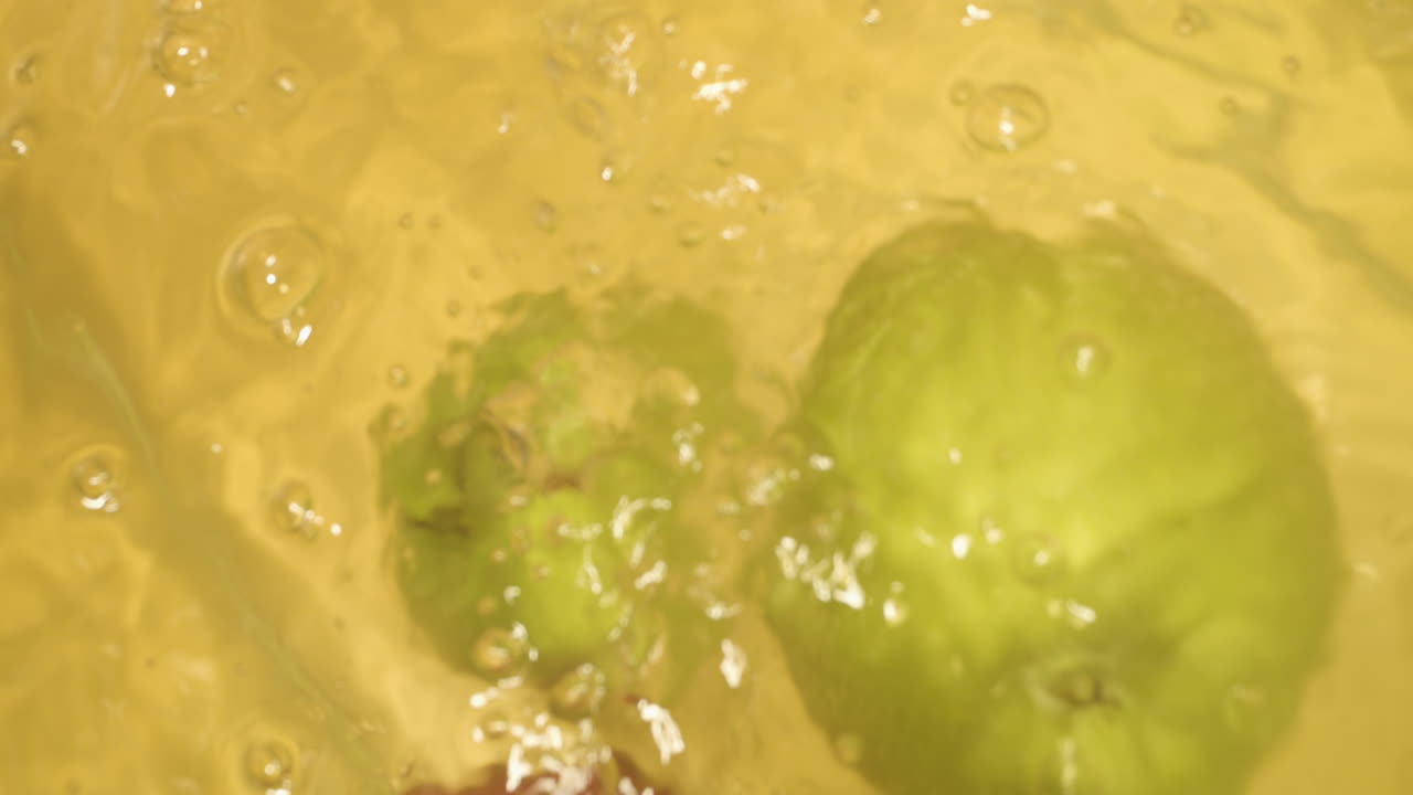 물에 떨어지는 다른 색상으로 사과의 총을 닫습니다