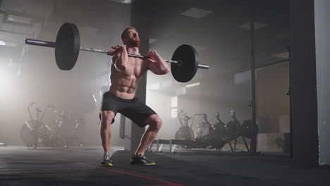 athletic beautiful man does overhead deadlift with a barbell in the gym. gorgeous male professional bodybuilder workout weight lift exercises in the authentic fit training facility