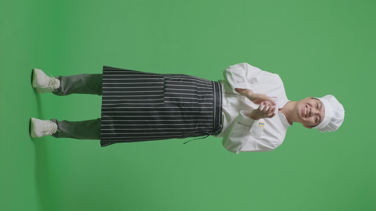 녹색 스크린 배경 스튜디오에 서 있는 동안 웃고 손을 는 아시아 남자 셰프의 몸이 가득 차 있습니다.