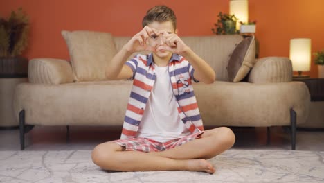 Boy-making-heart-symbol-for-camera.