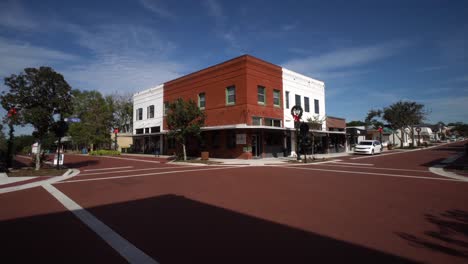 Wide-angle-push-in-past-shadows-of-tall-building-to-iconic-historic-red-and-white-brick-building-at-corner-of-intersection