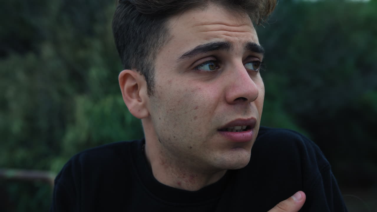 холодный молодой человек в зимний вечер дрожит и согревается снаружи