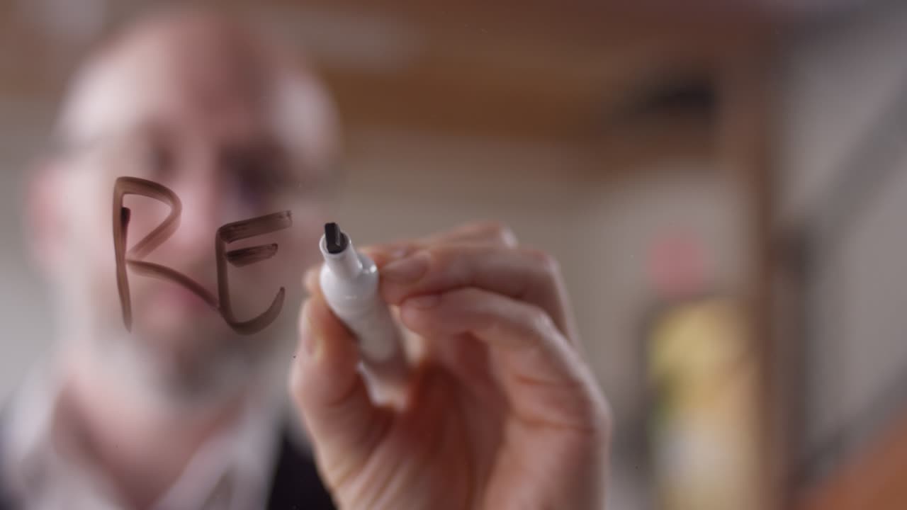 현대 사업가에 의해 건조 지우기 마커로 투명한 플렉시글라스에 쓰여진 "재상"