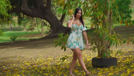 Latina-girl-walking-in-the-park-in-a-short-dress-in-fall-long-black-hair-flowing