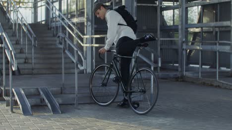 man carrying bicycle up the stairs