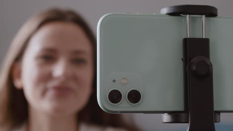 close up of a smartphone camera while filming a vlogger talking to her followers